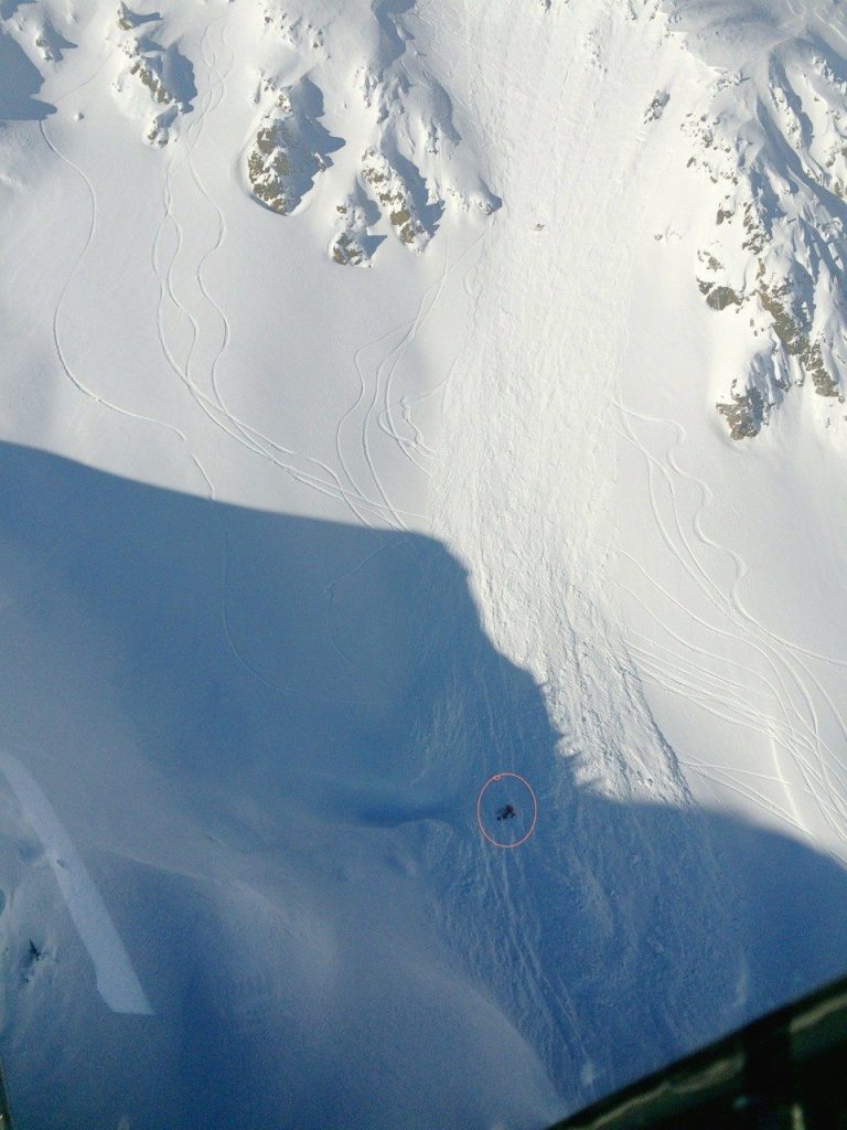 A shot taken by the pilot of the helicopter looking down on the snow.