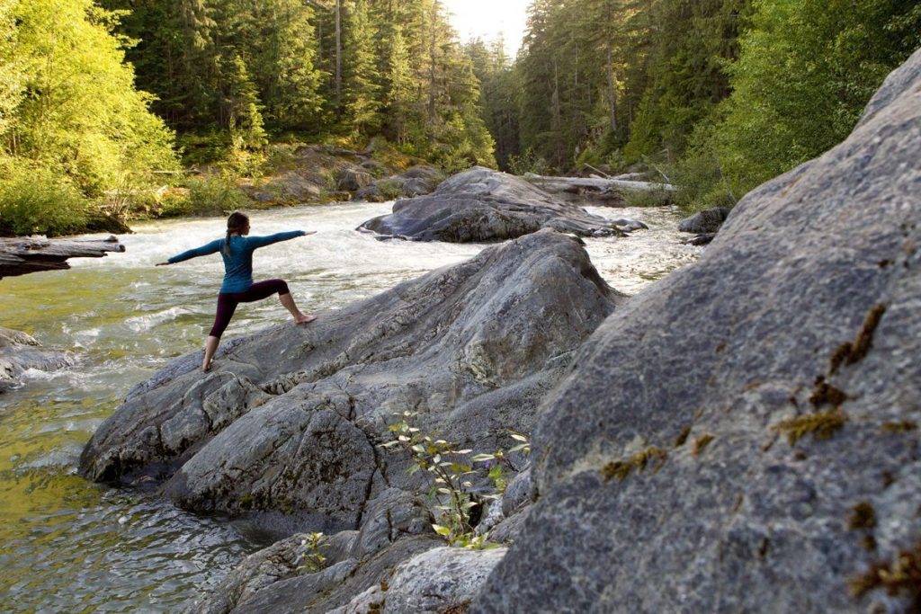 Holding warrior pose on the bank of the Cheakamus river.