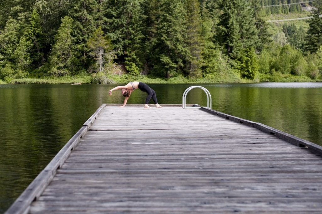 Practising yoga lakeside on a dock in Whistler.