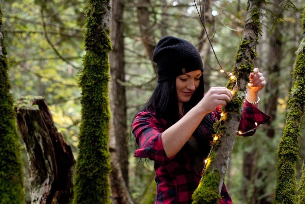 Setting up twinkle lights in the forest.