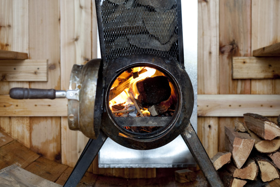 The welded stove inside the DIY sauna.