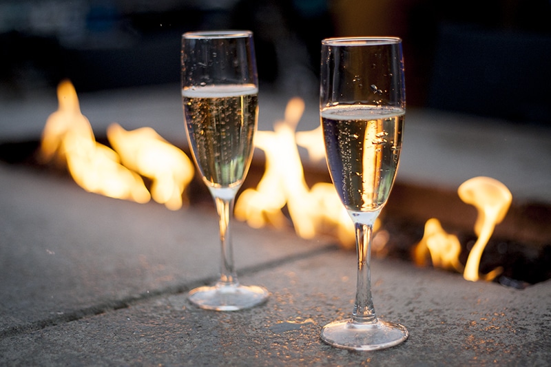 Glasses of champagne by an open fire.