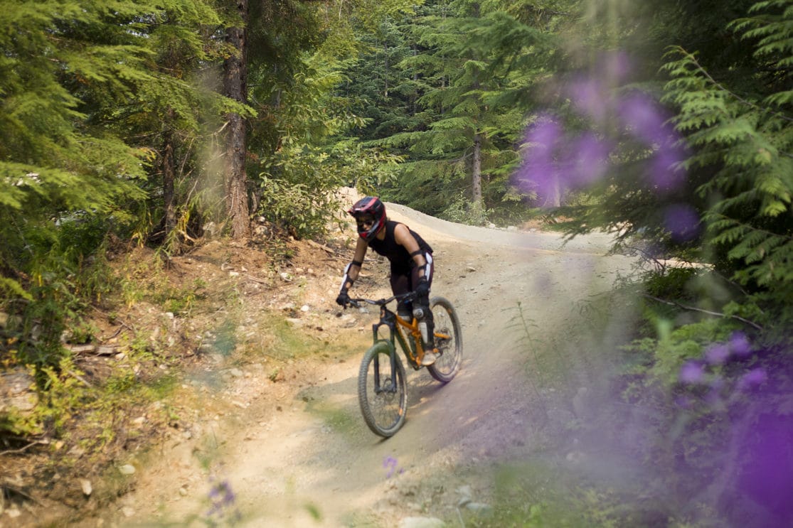 A female biker rides a trail in Whistler Bike Park.